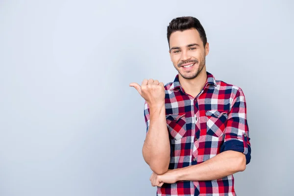 Look here! Young cheerful man with beaming smile is pointing at — Stock Photo, Image