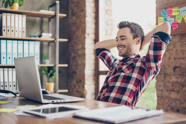 Vrolijke jonge brunet kerel is kijken op het scherm van zijn laptop, bij h — Stockfoto