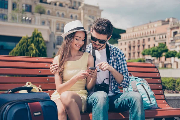 Juventude moderna está viajando, usando dispositivos de tecnologia, internet, desfrutando. Adolescentes se sentam ao ar livre com câmera e pda, em boné e óculos — Fotografia de Stock