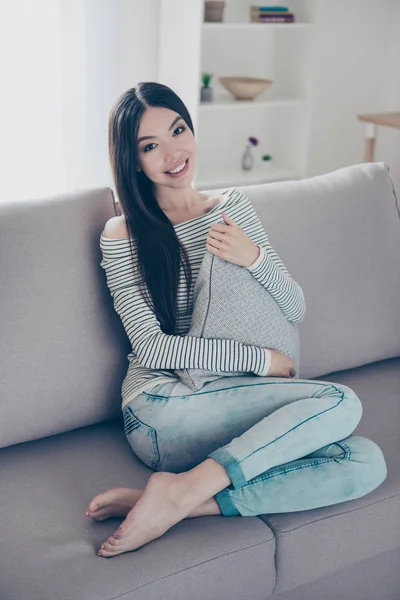 Joven encantador asiático chica es holding gris almohada, sentado en bei — Foto de Stock