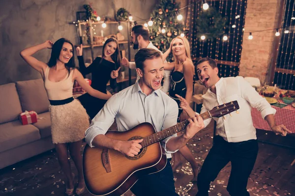 Celebrating newyear. Young handsome musician makes a noise with — Stock Photo, Image