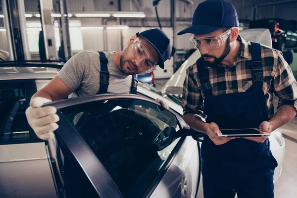 Professionalism, maintenance. Two busy expert engineers at mecha