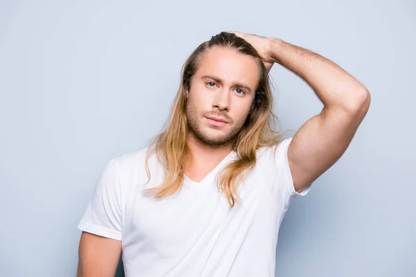 Bonito homem brutal com cerdas está penteando seu longo cabelo loiro — Fotografia de Stock