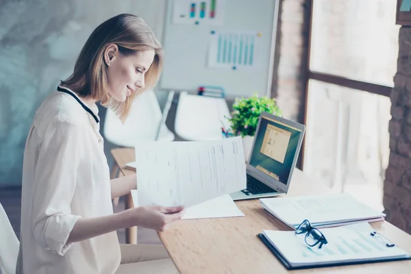 Fleißige Assistentin sitzt an ihrem Arbeitsplatz und prüft Dokumente — Stockfoto