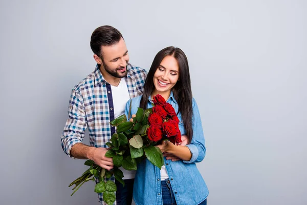 Бородатий чоловік представляє букет з червоних троянд своєму чарівному, щасливому — стокове фото