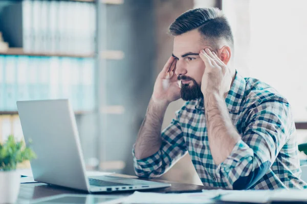 Allvarliga, eftertänksam, skäggiga killen som sitter vid skrivbord arbetsplatsen i — Stockfoto