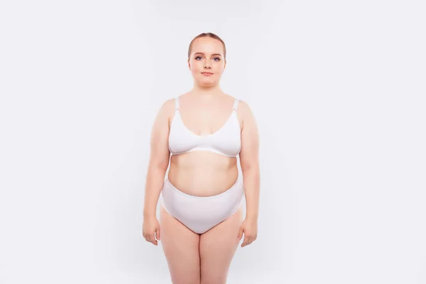 Back view of unrecognizable fat plump plus-size overweight woman standing  in beige bra, underpants near bed, showing squeezing excessive fat of back.  Body positive, obesity, weight loss, liposuction. Photos