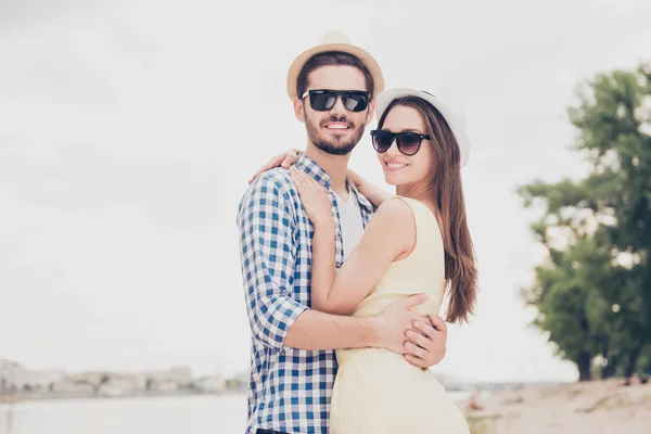 Hombre atractivo en gorra con cerdas abrazando a mujer encantadora con l — Foto de Stock