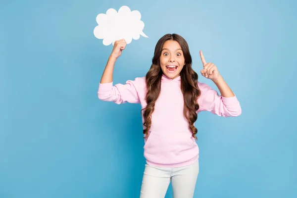 Photo of pretty little lady wavy hairdo hold empty paper cloud raising finger have creative idea for dialogue answer wear casual sports wear pink hood isolated blue color background — Stock Photo, Image