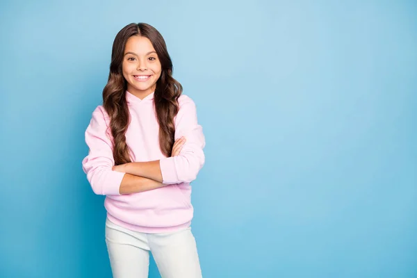 Foto de uma senhora muito pequena longo penteado ondulado segurando as mãos cruzado dente sorrindo desgaste casual capuz pulôver rosa isolado azul cor de fundo — Fotografia de Stock