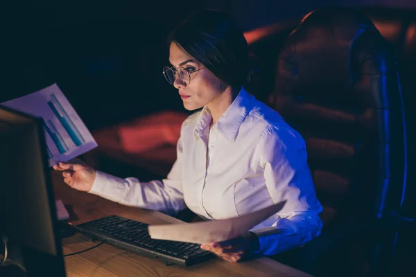 Close-up portrait of nice attractive stylish skilled focused lady economist executive manager marketer analyzing income profit invest rate expenses progress deadline at night dark work place station — ストック写真