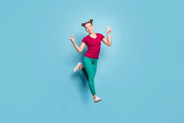 Foto de tamaño corporal de longitud completa de urgente novia emocional positiva que lleva pantalones verdes que le muestra doble v-signo sonriendo toothily aislado sobre fondo de color pastel azul —  Fotos de Stock