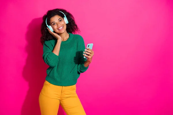 현대 헤드폰을 쓰고 있는 긍정적 이고 명랑 한 소녀의 사진은 스마트폰을 사용하여 재생 가능 한 스테레오 노래를 듣는다. — 스톡 사진
