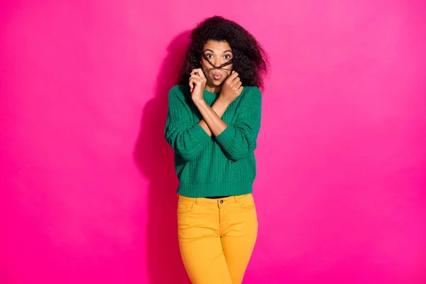 Porträtt av roliga funky afro amerikansk flicka ha kul fritid på vintern lura hålla frisyr bära snygga jumper byxor isolerad över ljusa färg bakgrund — Stockfoto
