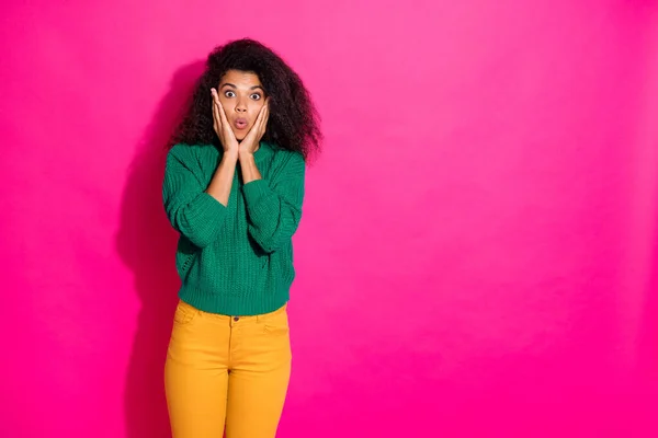 Portrait of astonished girl hear wonderful unexpected novelty don believe scream wow wear green pullover yellow pants in winter isolated over pink color background