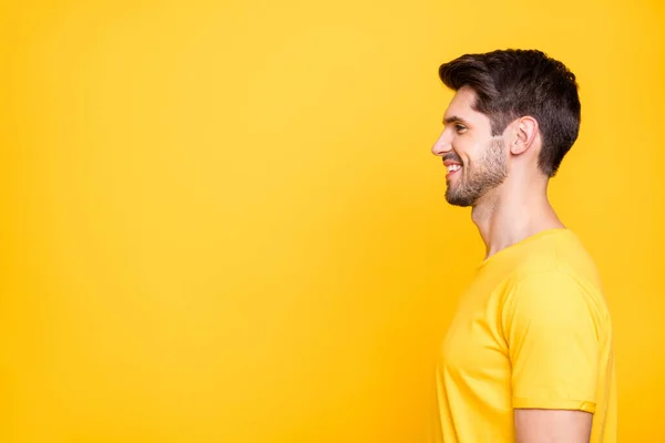 Foto de perfil de joven hombre de negocios guapo freelancer buscando espacio vacío toothy sonriente desgaste casual camiseta aislada de color amarillo brillante fondo —  Fotos de Stock