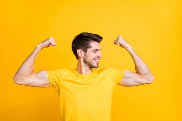 Close-up portrait of his he nice attractive content strong sportive cheerful cheery guy demonstrating muscles isolated over bright vivid shine vibrant yellow color background — ストック写真
