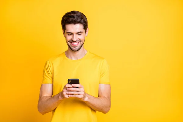 Yakışıklı bir adamın telefonda arkadaşlarıyla sohbet ederken çekilmiş fotoğrafı geleceğin havalı öğrencilerinin partisini tartışırken günlük tişört giyerken izole edilmiş sarı arka plan. — Stok fotoğraf