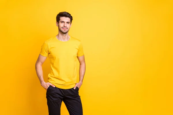 Photo of serious dreamy man standing confidently with hands in pockets looking into camera next to empty space isolated over vibrant color background — ストック写真