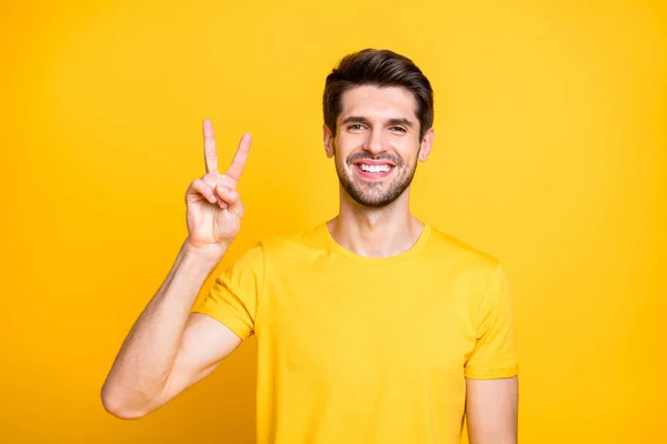 Primer plano retrato de su agradable atractivo divertido alegre alegre chico usando camiseta mostrando v-signo de buen humor aislado sobre brillante brillo vivo vibrante color amarillo fondo — Foto de Stock