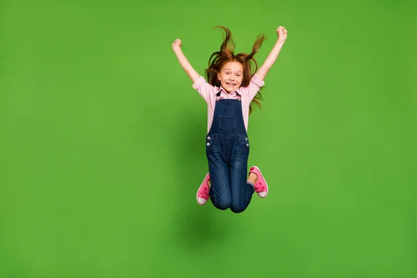 Fotografie completă a corpului unui elev destul de mic sărind de înaltă bucurie vacanțe de vară păr care zboară cald vânt uzură casual denim general cămașă roz izolat fundal verde — Fotografie, imagine de stoc