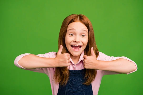 Closeup photo of excited little ginger schoolchild raise thumb fingers up recommending cool tutor in history wear denim overall pink shirt isolated green background — 스톡 사진