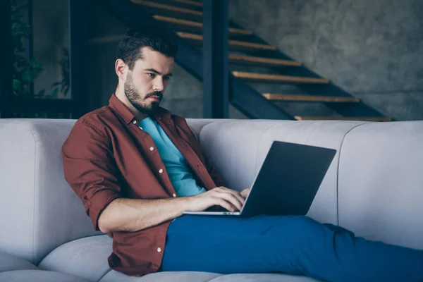 Foto de perfil de cara bonito segurando notebook sobre joelhos trabalhador freelancer sofá deitado acolhedor na sala de estar apartamento moderno em ambientes fechados casual vestido — Fotografia de Stock