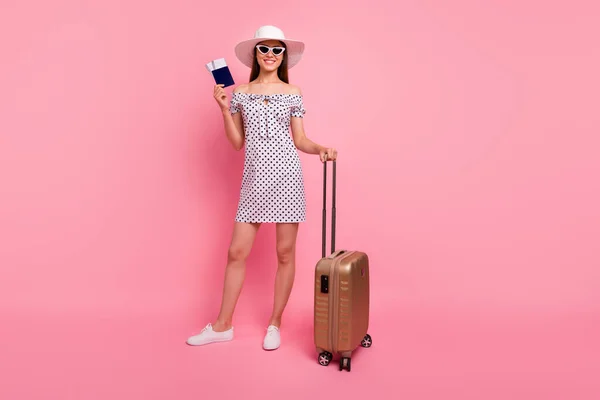 Πλήρες μήκος σώματος μέγεθος φωτογραφία της Νίκαιας αυτοπεποίθηση χαρούμενη ενεργητικός κορίτσι που μόλις προσγειώθηκε στο εξωτερικό χώρα φορώντας καπέλο, ενώ απομονώνονται με ροζ φόντο — Φωτογραφία Αρχείου
