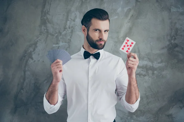 Foto de inteligente inteligente jugador de cartas que le muestra se centra mediante la demostración de diferentes palos de cartas aisladas sobre fondo de color de pared de hormigón gris —  Fotos de Stock