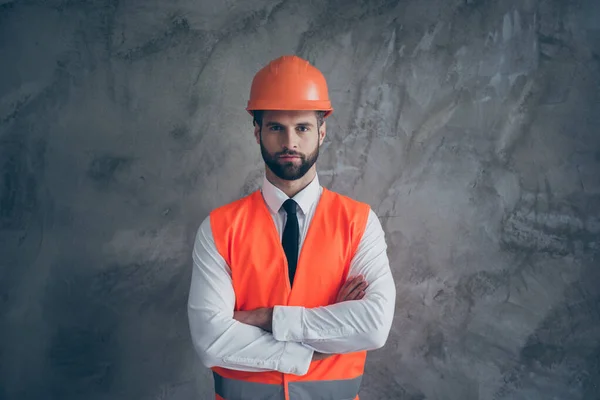 Porträt eines selbstbewussten coolen Bauunternehmers, der bereit ist, ein großes Haus zu bauen, trägt orangefarbene Uniform mit weißem Hemd, schwarzer Krawatte und grauem Hintergrund — Stockfoto