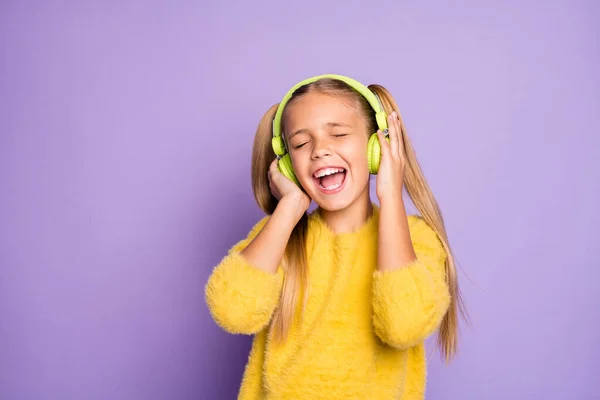 Retrato de niño loco funky uso auriculares verdes escuchar música de radio cantar canción usar suéter de estilo casual aislado sobre fondo de color púrpura — Foto de Stock