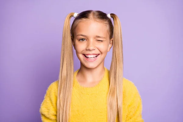 Foto de linda chica alegre positiva guiñándote el ojo para atraer tu atención aislada sobre el fondo de color violeta pastel —  Fotos de Stock