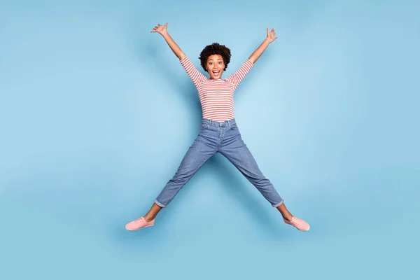 Full längd foto av funky rolig afro amerikansk flicka hoppa upp händerna som hon stjärna bära casual stil outfit isolerad över blå färg bakgrund — Stockfoto
