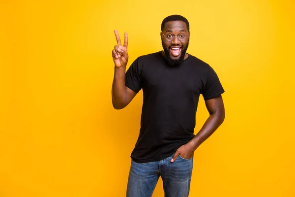 Photo of cheerful positive handsome attractive man with hands in pockets of jeans showing v-sign with amazement on face isolated bright color background — Stock Photo, Image