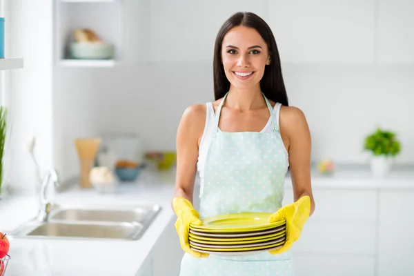 Clean plates concept, Beautiful made hold pile of dishes she washed with yellow protective rubber gloves feel content stray in light white kitchen indoors modern flat — Stock Photo, Image