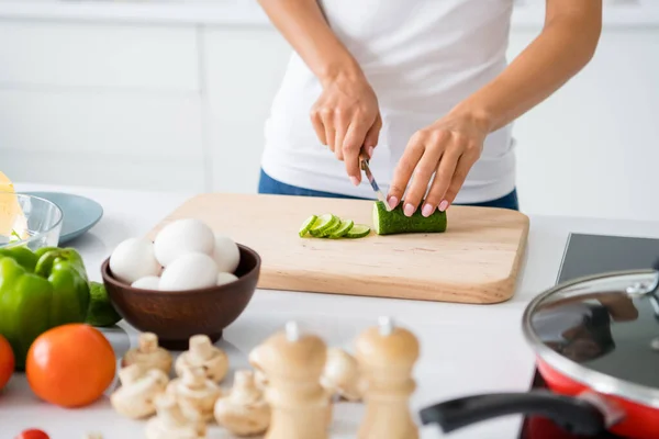 Close up cropped photo of joyful housewife prepare feast for her veggie family cutting green organic cucumber on chopping board in kitchen white house indoors — ストック写真
