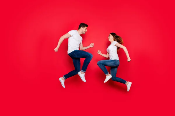 Seitenprofil Ganzkörpergröße Foto von fröhlich nett nettes Paar Freundin Freund stoßen ineinander lächelnd Laufen Springen Jeans Denim weißes T-Shirt isoliert lebendige Farbe Hintergrund — Stockfoto