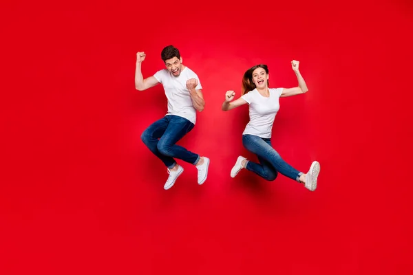 Volledige lichaamslengte foto van vrolijke positieve springen opgewonden vreugde dolblij vriendin vriendje dragen jeans denim wit t-shirt schoenen schreeuwen ja ja geïsoleerde levendige kleur achtergrond — Stockfoto