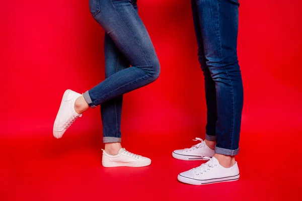 Foto de agradável casual namorada namorado pernas em jeans jeans calçado tênis branco isolado cor viva fundo — Fotografia de Stock