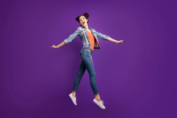 Foto de perfil de longitud completa de la señora divertida estudiante saltando alto estado de ánimo increíble caminando por la calle desgaste ropa vaquera casual ropa de moda aislado color púrpura fondo — Foto de Stock