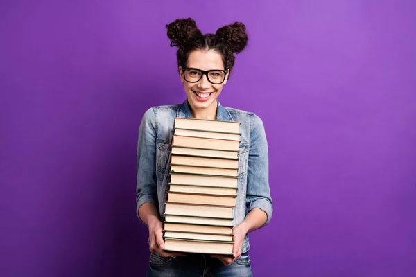 Foto van grappige student dame met veel boeken dragen literatuur naar huis in liefde met het lezen van slijtage specs casual denim outfit geïsoleerde paarse kleur achtergrond — Stockfoto