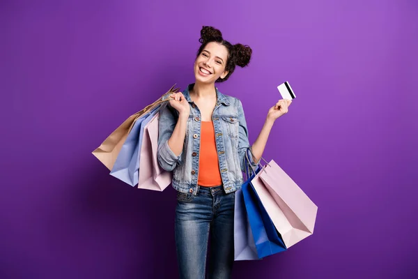 Photo of amazing lady holding many packs in hands made foreign shopping excited using credit card to pay wear casual denim outfit isolated purple color background — Stock Photo, Image