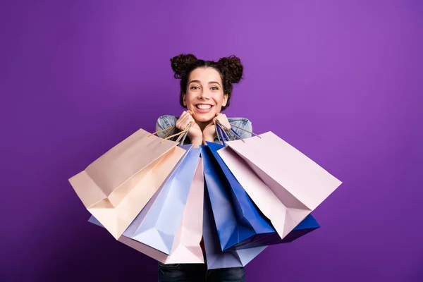 Portrét pozitivní veselá dívka bavte se na nákupním hold mnoho tašek balíčky pocit obsahu výraz nosit džíny bunda izolované přes fialové barvy pozadí — Stock fotografie