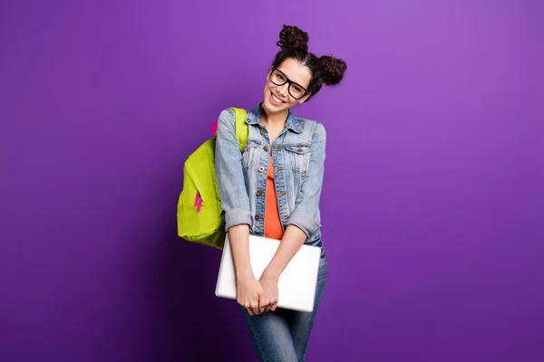 Портрет милої дівчини середньої школи, яка готова до університетської лекції, тримає комп'ютерний одяг у повсякденному стилі, ізольований на фіолетовому кольоровому фоні — стокове фото