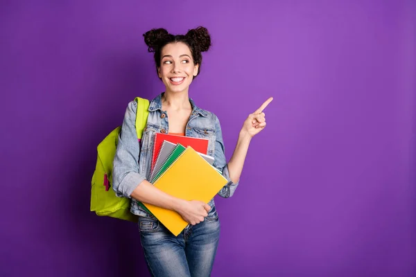 Portrét pozitivní veselý středoškolačka bod ukazováček držet notebooky současné akademické kurzy informace nosit stylové módní oblečení zelená taška izolované přes fialové barvy pozadí — Stock fotografie