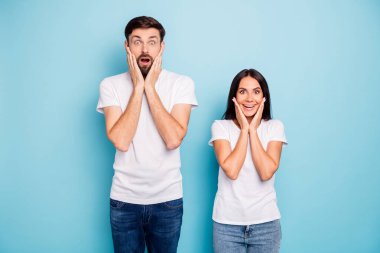 Portrait of impressed content lady and guy spouses hear incredible novelties scream wow omg wear good look outfit isolated over blue color background clipart