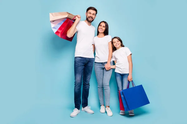 Foto de tamaño completo de tres clientes personas mamá papá escolar con pelo marrón tienda abrazo abrazo agarrar bolsos de mano negro viernes ganga desgaste blanco camiseta vaqueros jeans zapatillas aisladas color azul fondo — Foto de Stock