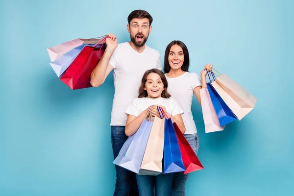 50 de descuento. Un verdadero concepto de ganga. Retrato de emocionado tres personas mamá papá escolar tienda centro celebrar bolsas grito wow omg desgaste blanco camiseta vaqueros aislados sobre fondo de color azul — Foto de Stock