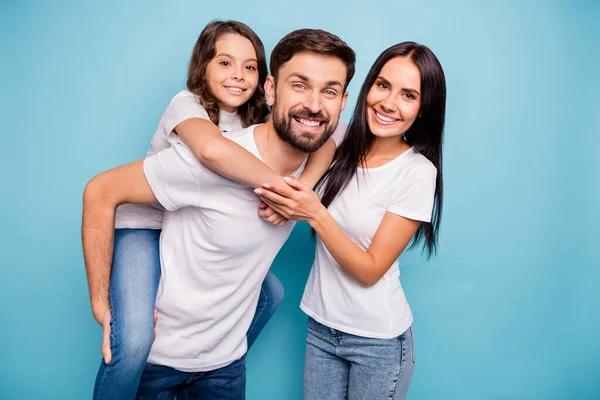 Retrato de positivo alegre funky tres personas llevan cabrito a cuestas disfrutar de fines de semana usar blanco camiseta vaqueros vaqueros denim aislado sobre fondo de color azul — Foto de Stock