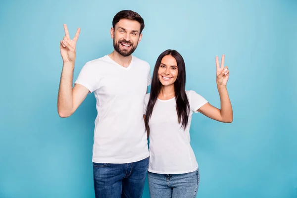 Portrait of cheerful lovely spouses have free time weekends make v-signs wear white stylish trendy t-shirt denim jeans isolated over blue color background — Stock Photo, Image